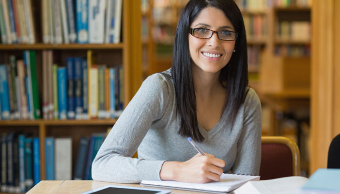 Woman in a library writing in a book