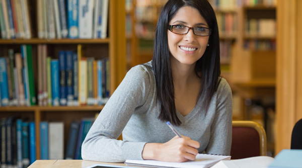 Woman in a library writing in a book